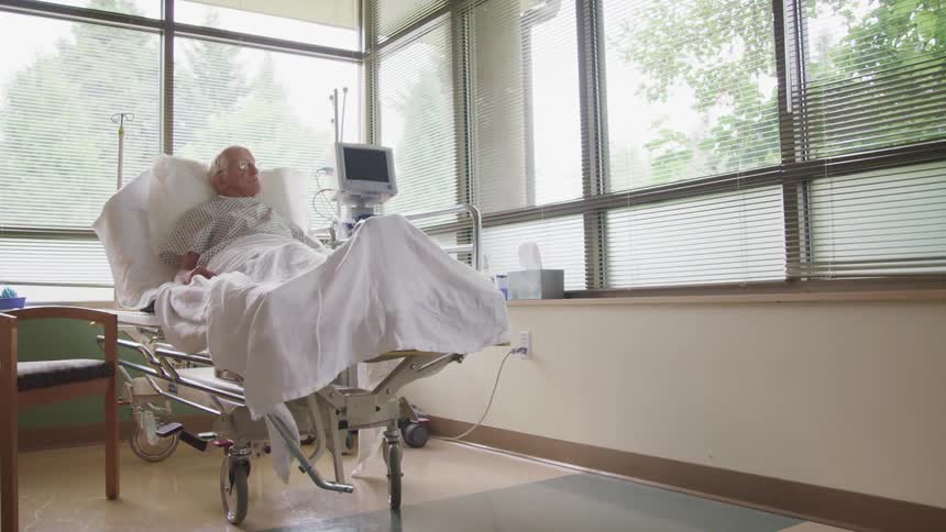 An elderly man lying in a hospital bed