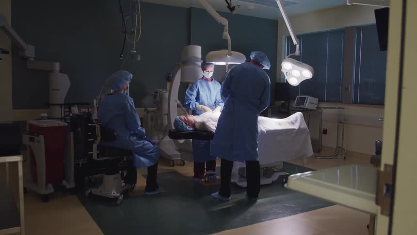 A group of medical professionals perform surgery in a hospital
