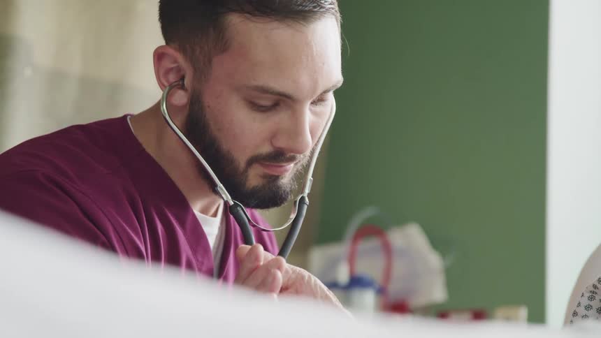 A doctor is examining a patient with a stethoscope