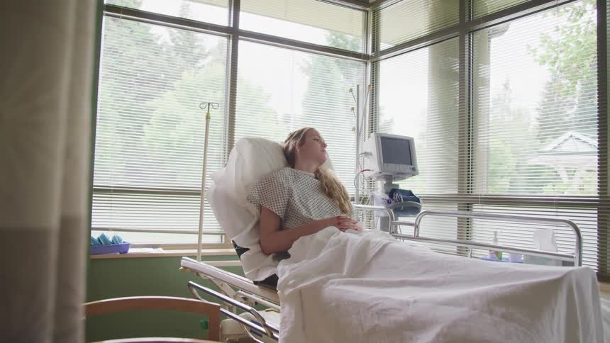 A teenage girl lying in a hospital bed