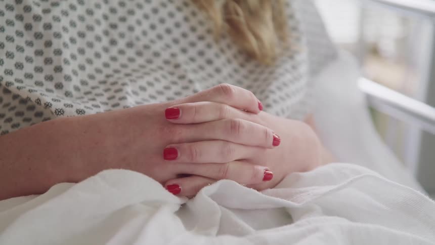 A woman is laying in the hospital bed
