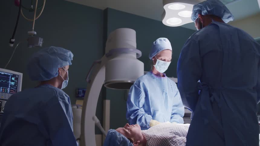 Surgical team works on patient in operating theater