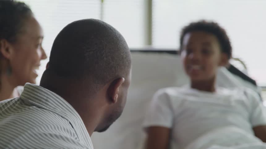 A patient smiles with visitors in the hospital room