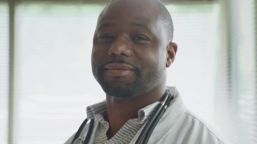 A doctor is smiling in the hospital room