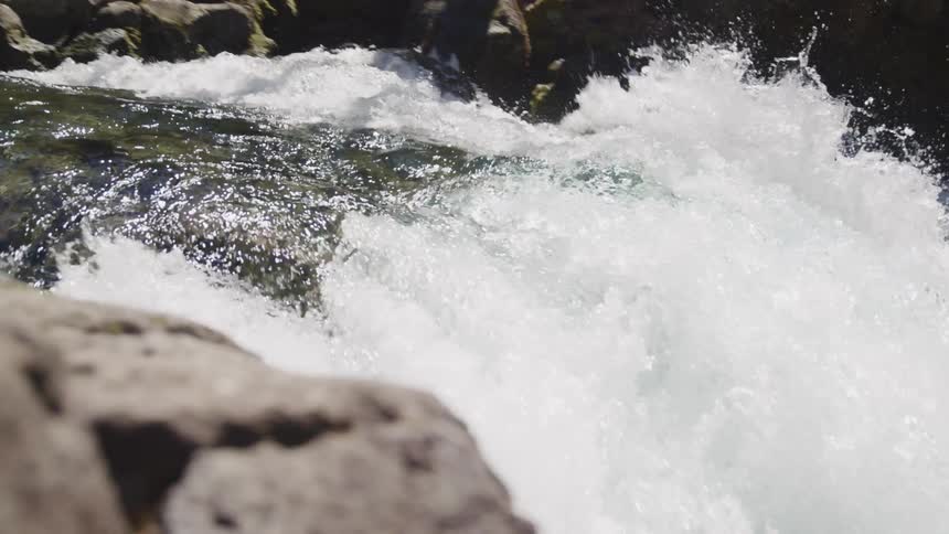 A waterfall flows over a rocky cliff in nature