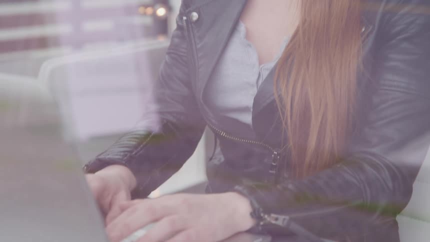 A woman sitting at a desk at home typing on her laptop