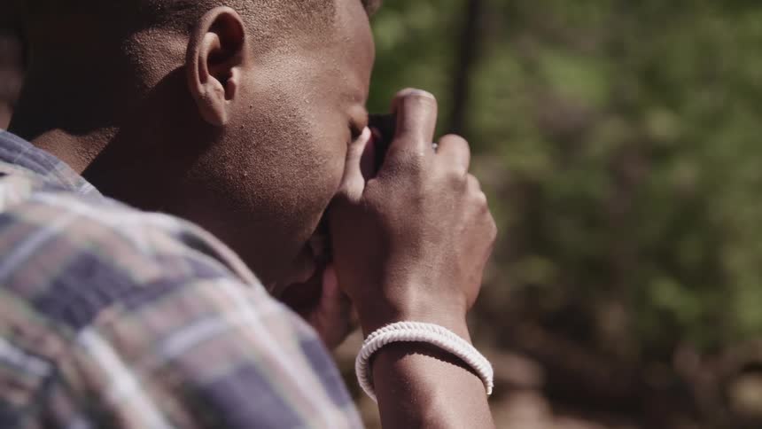 Man uses a camera to take pictures of the forest
