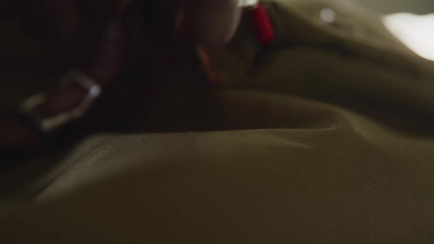 A person closing the zipper on a backpack and picking up the bag