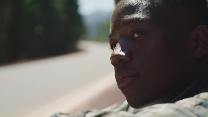 A teenage boy sitting on the side of a road