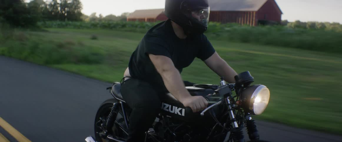 A man riding a motorcycle in the country during the day