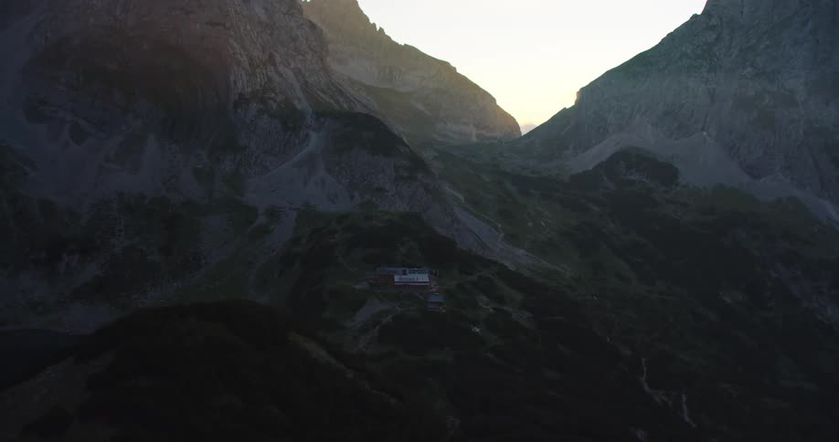 An aerial view of a remote building surrounded by mountains