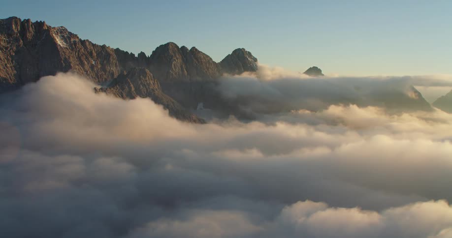 An aerial view of clouds around a mountain range