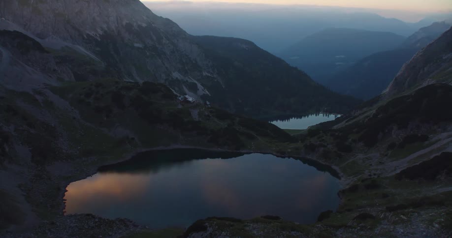 A building between a pair of lakes in a valley high in the mountains