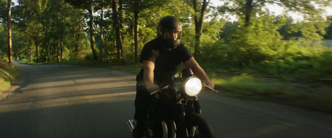 A man riding a motorcycle in the country during the day