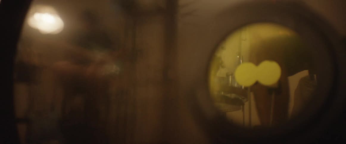 A performing guitarist is reflected in the vibrating head of a bass drum