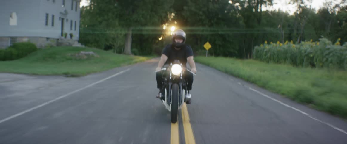 A motorcycle drives over a yellow line in the road