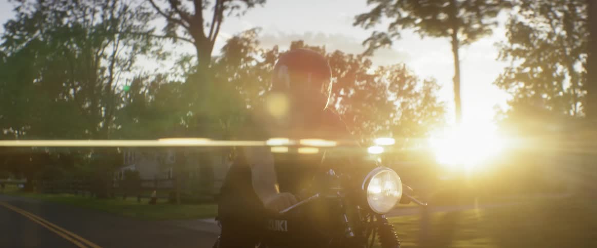 A man is riding a motorcycle down a street