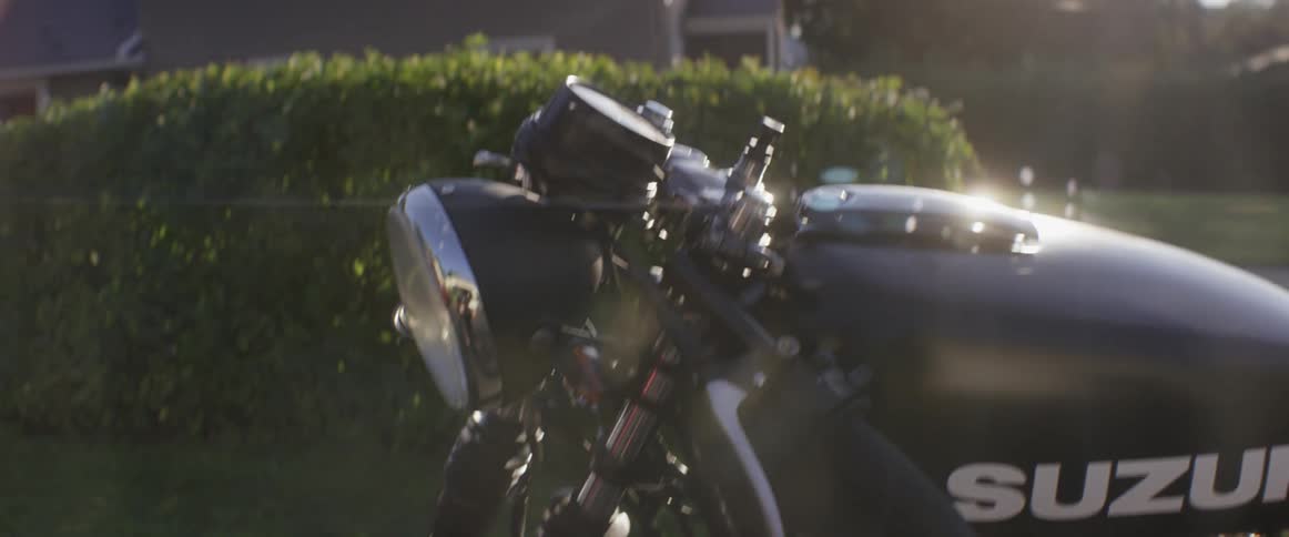 The sun shines down on a parked motorcycle
