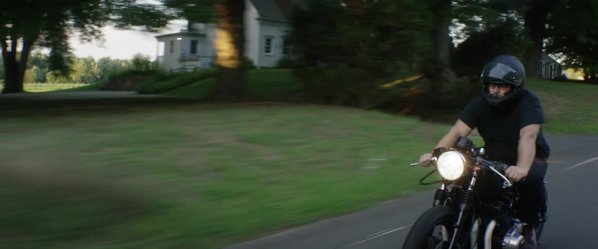 A man rides a motorcycle in the daytime