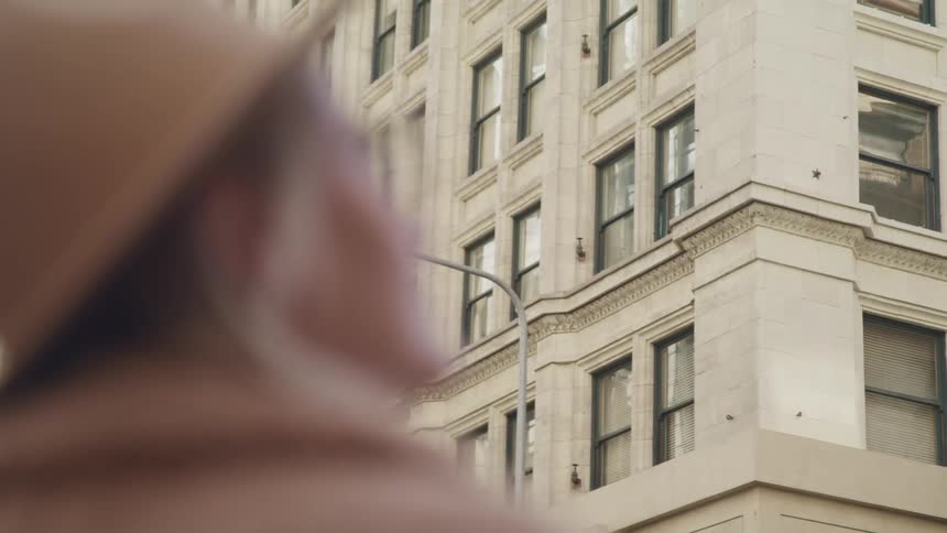 A woman is standing outdoors in a downtown city