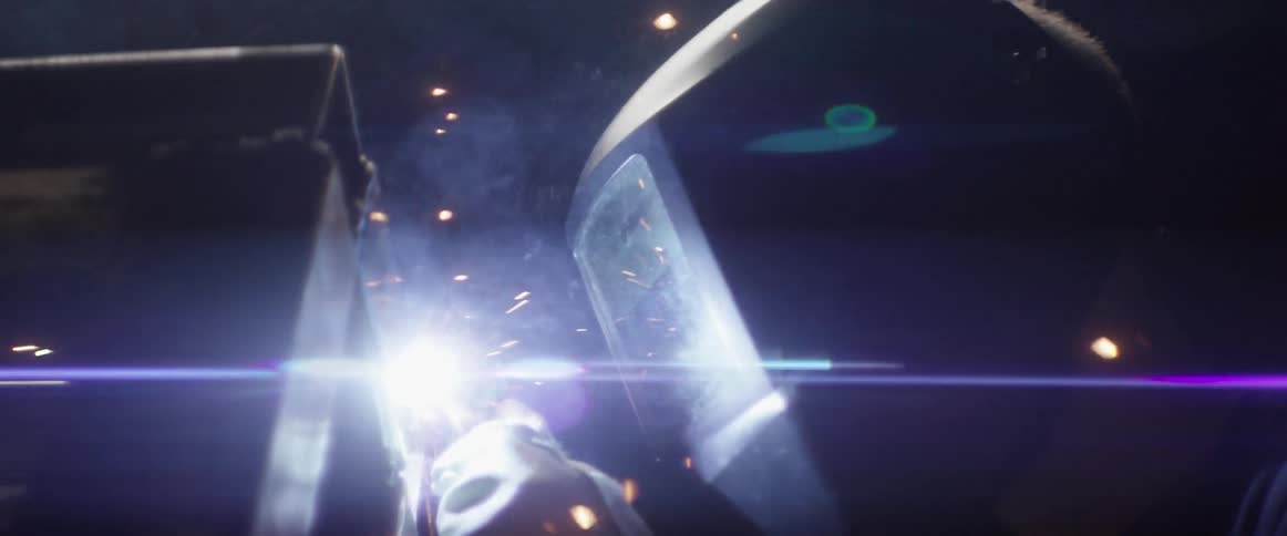 A welder works with sparks flying around