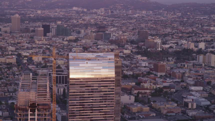 The reflective facade of a skyscraper looming over a metropolis
