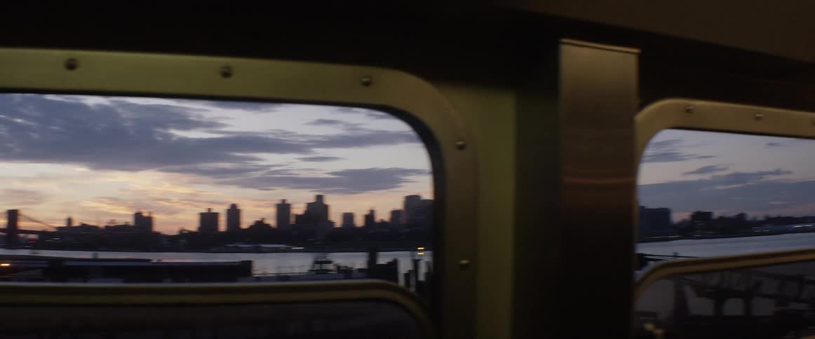 A city skyline through the window of a train car
