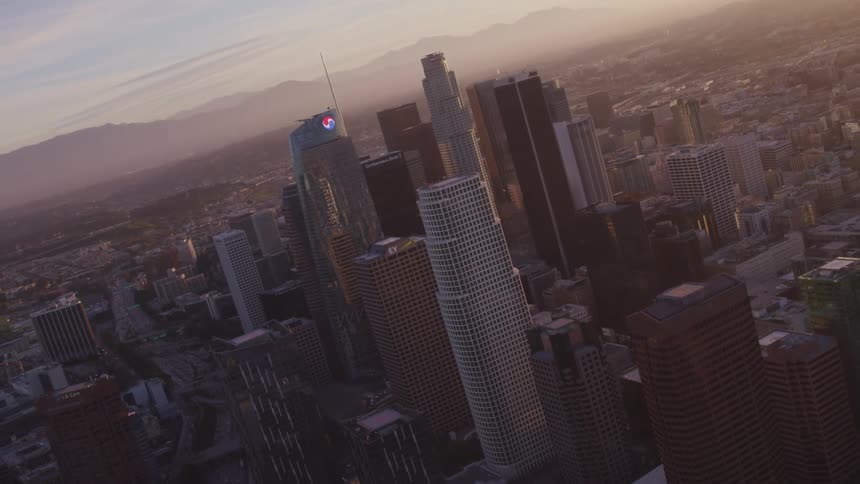 Aerial view of high rise buildings and office buildings with houses and roads on the horizon in city