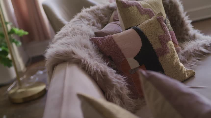 Throw pillows and a fuzzy blanket on a sofa in a living room