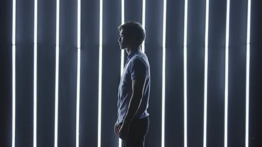 A man stands in front of rows of lights