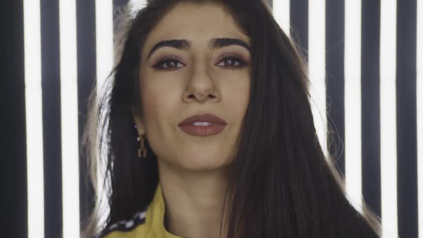 Woman wearing yellow jacket looks up to the camera