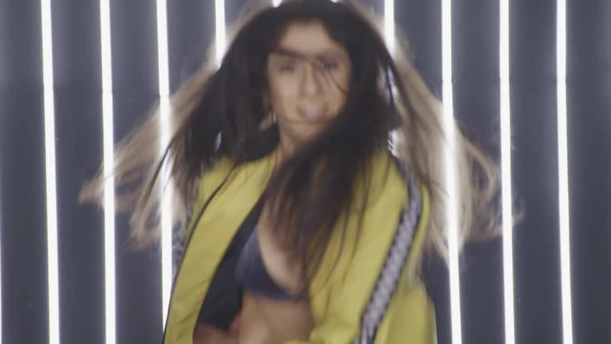 A woman is dancing in front of the lights