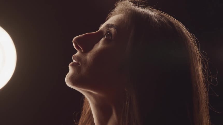 A woman is looking up by the lights