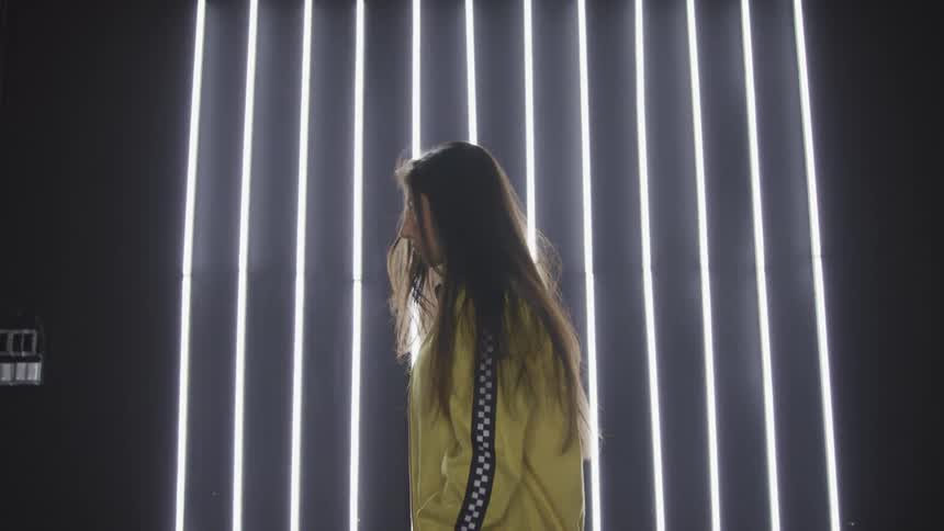 A woman is wearing a yellow jacket in front of the lights
