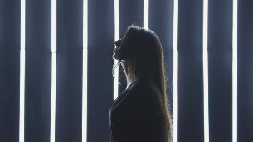 A female caucasian standing and breathing deeply and meditating