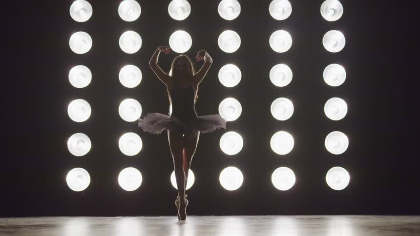 A woman is ballet dancing on stage