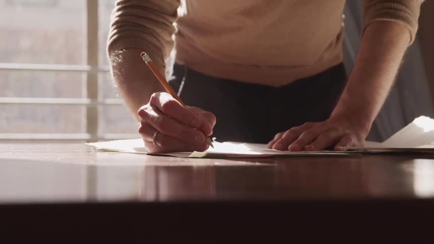 A man is writing on a piece of paper