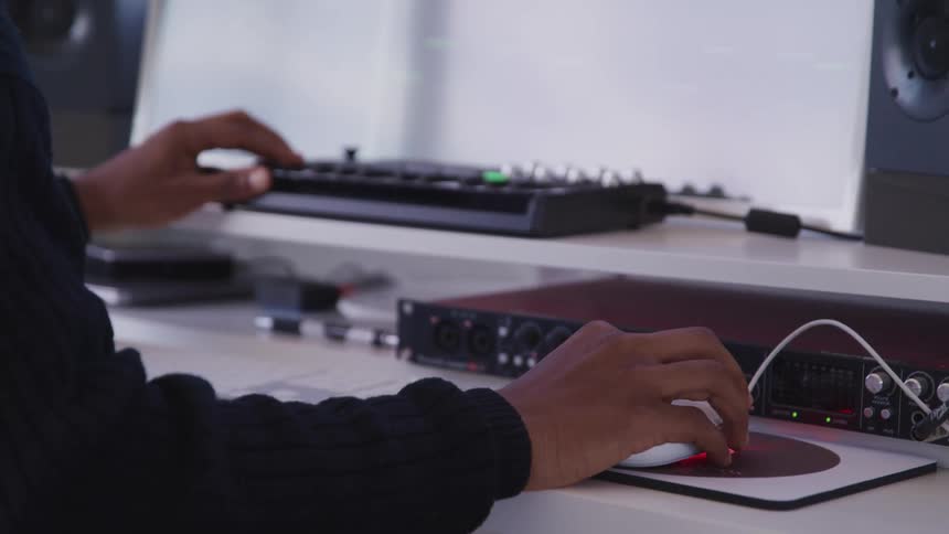 A person is working at the computer and mixer