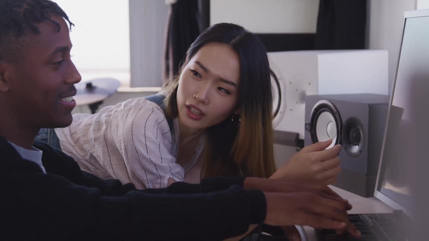 A man and woman talk while looking at the computer