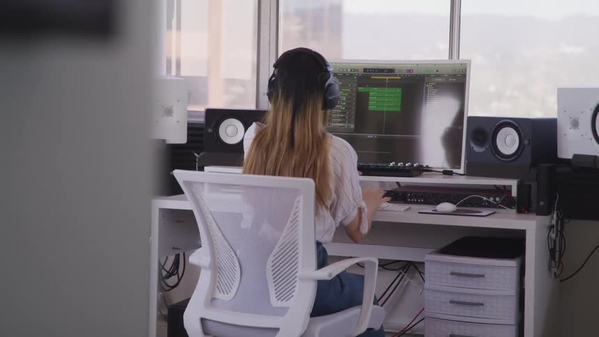 A woman is working on a computer in the studio
