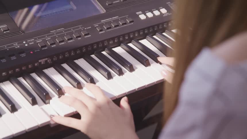 A girl is playing the piano indoors