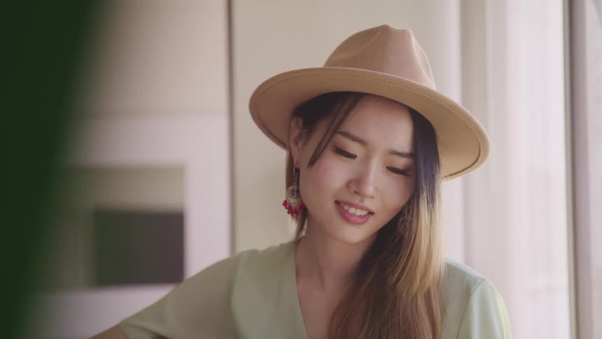A teenage girl playing a musical instrument at home
