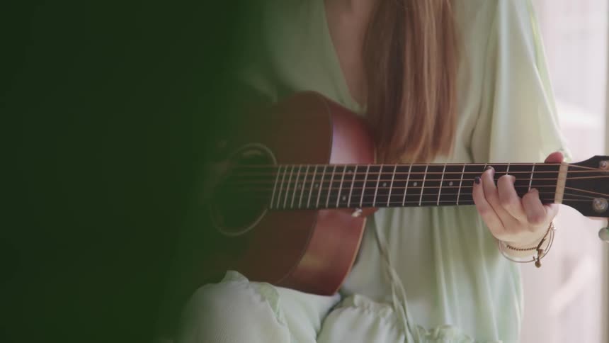 A woman is playing guitar indoors