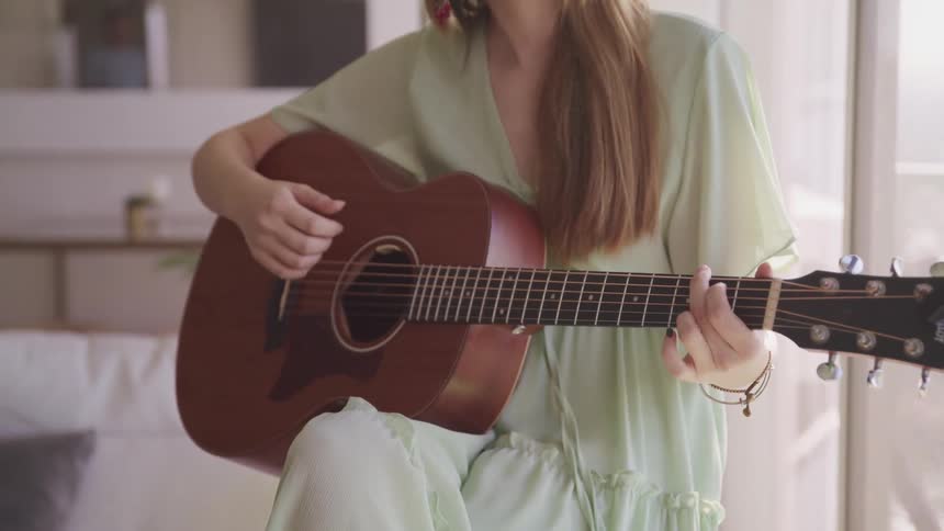 A woman is playing the guitar