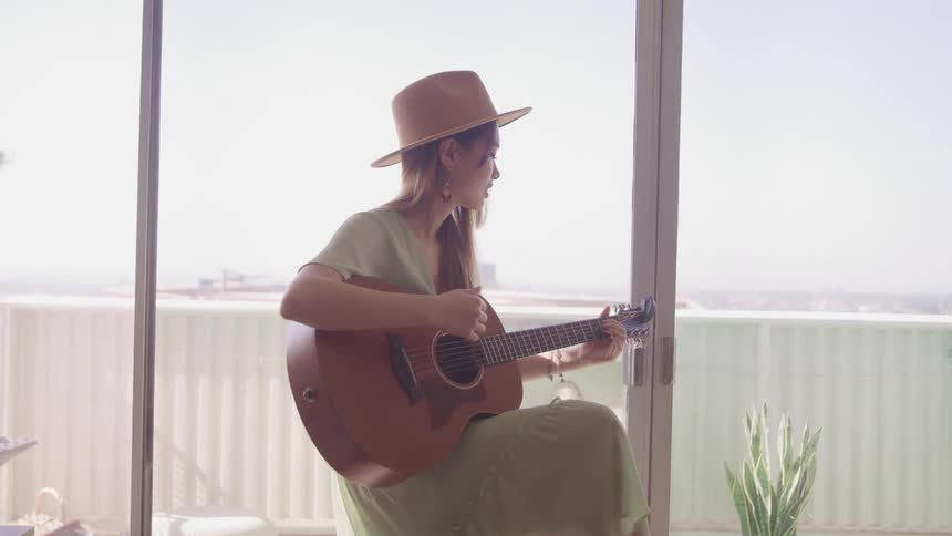A woman is playing a guitar indoors