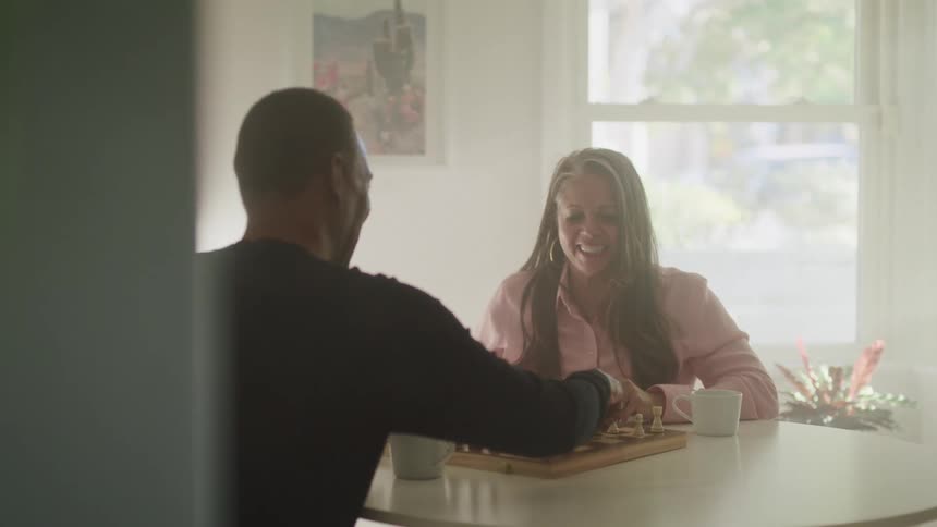 A man and woman have fun playing chess