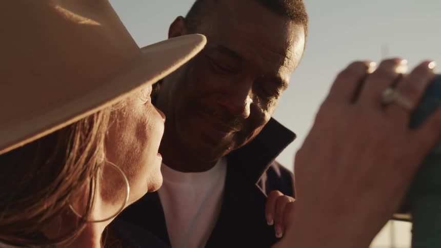 Adult couple look at each other lovingly at sunset