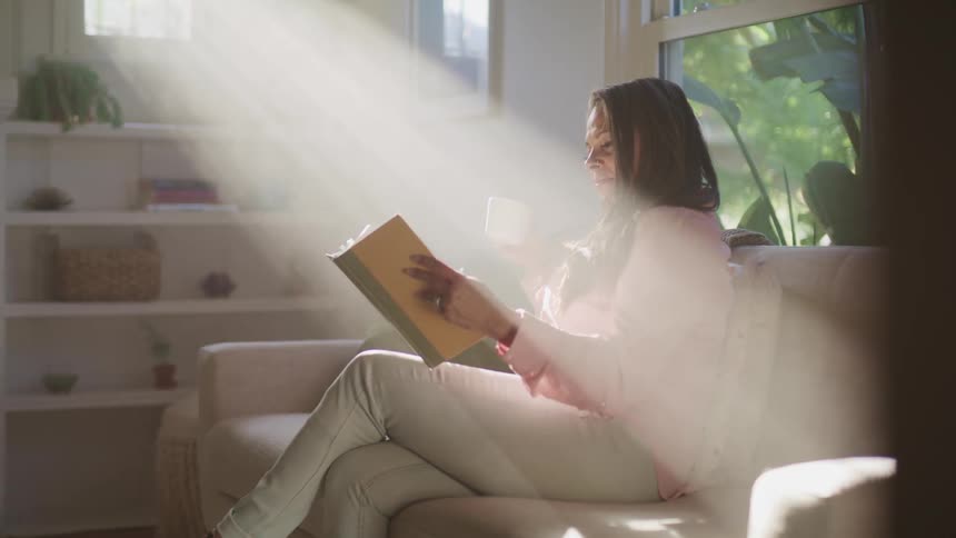 A woman is reading a book indoors