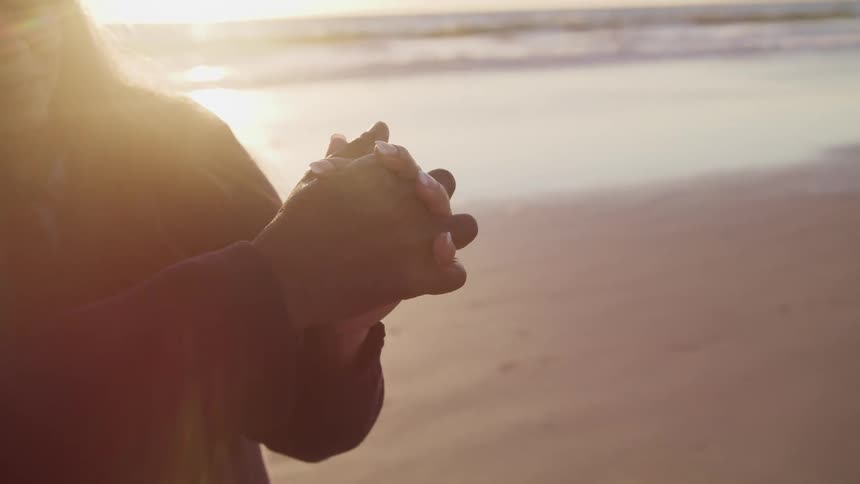 A man and woman slow dance on a beach