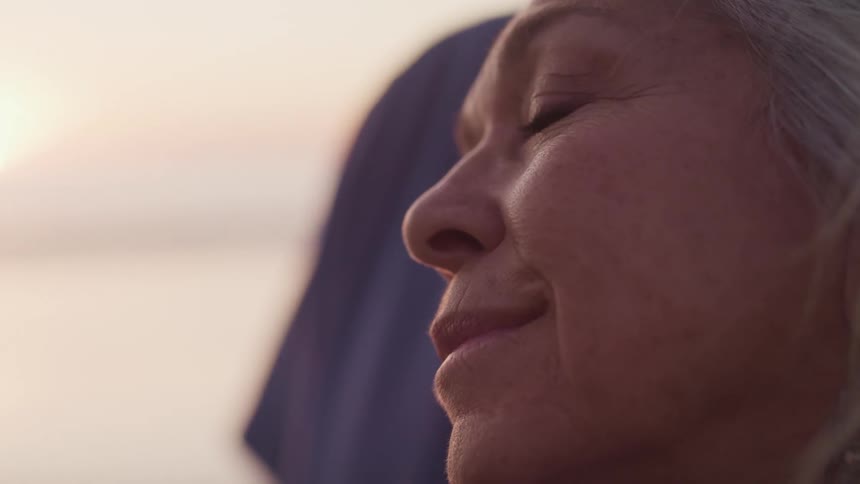 An elderly woman looking forward and smiling